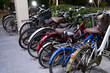 Several old bicycles lined up under the apartment building