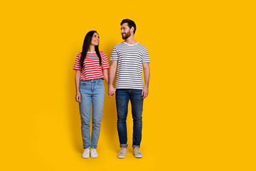 Sticker - Full size photo of friendly couple girl guy dressed striped t-shirt look at each other arms together isolated on yellow color background