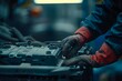 Hands of a mechanic performing car battery maintenance and checking electrical system in an auto repair service. Concept Car Battery Maintenance, Mechanics, Electrical System Check