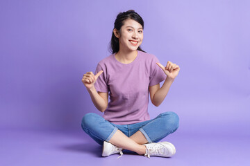 Wall Mural - Photo of young Asian girl on purple background