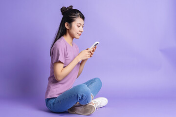 Wall Mural - Photo of young Asian girl on purple background