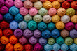 Background with stack of colorful balls of yarn in green, purple, pink, violet, and aqua