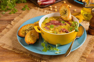 Wall Mural - Traditional Polish pea soup. Prepared with smoked meat. Served in a yellow bowl with croutons. Home made.