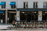 Fototapeta Paryż - Cozy street with tables of cafe  in Paris, France. Cityscape of Paris. Architecture and landmarks of Paris
