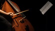 cellist playing cello under spotlight