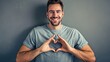 Man laughingly pointing to heart rhythm on his heart, forming a heart with his fingers 