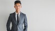 A good-looking, young Asian businessman standing alone on a white background with room for text.