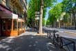 Cozy street with tables of cafe and bicycle in Paris, France. Cityscape of Paris. Architecture and landmarks of Paris