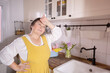 tired woman in apron wipes sweat off forehead, indicating busy kitchen session, spring home cleaning, Fatigue and exhaustion, satisfaction takes in work and importance of cleanliness, household labor