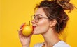A female model is presented with her face holding an apple, evoking themes of choice against a yellow backdrop