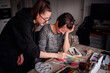 © Иванна Емельянова - A moment of creative consultation, as one artist guides another, their collective focus on the watercolor artwork unfolding before them