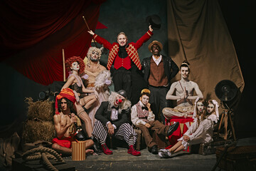 Diverse cast of vintage circus performers poses over dark retro circus backstage background. Promotional poster for upcoming performances. Concept of circus, theater, performance, show, retro and