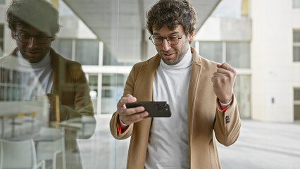 Sticker - A stylish young man interacts with his smartphone on a city street, reflecting contemporary urban life.