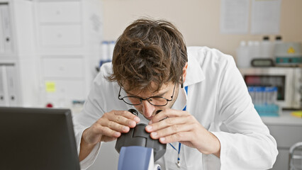 Wall Mural - A young scientist examines samples using a microscope in a modern laboratory setting.