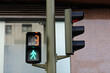 Pedestrian traffic light with green permissive signal and countdown, little green walking man, number 3, building background. Traffic lights regulate the movement of pedestrians across the roadway.