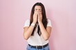 Young brunette woman standing over pink background rubbing eyes for fatigue and headache, sleepy and tired expression. vision problem