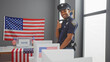 African american police officer giving thumbs up in a us election voting center with american flags