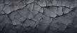 Close-up view of cracked wallpaper in shades of black and grey against a dark background