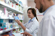 © New Africa - Professional pharmacists near shelves with merchandise in modern drugstore