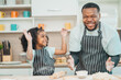 © chokniti - In a home kitchen, black father and his daughter bond over cooking a meal food, their laughter and love filling the air, embodying the joy of African American family life, Father's Day concept