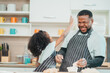 © chokniti - In a home kitchen, black father and his daughter bond over cooking a meal food, their laughter and love filling the air, embodying the joy of African American family life, Father's Day concept