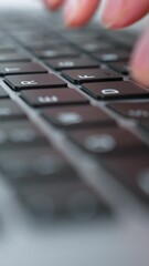 Vertical Screen: Closeup fingers typing text on laptop keyboard, selective focus. Tracking shot programmer or office worker or copywriter doing job. Concept of business