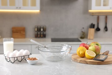 Wall Mural - Metal whisk, bowl, grater and different products on gray marble table in kitchen