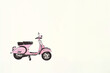 vespa rose et noir, scooter italien selle 2 places, sur béquille sur un fond jaune clair avec espace négatif copy space
