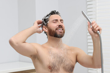 Poster - Happy man washing his hair with shampoo in shower