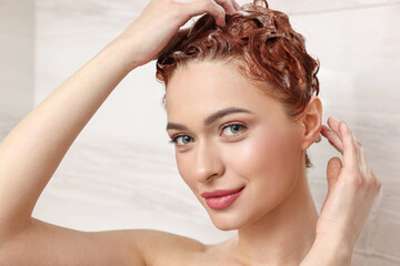 Poster - Happy young woman washing her hair with shampoo in shower