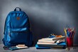 Blue school bag with books and school accessories