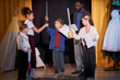 © Seventyfour - Full length portrait of children rehearsing school play on stage in theater with little boy prince reciting lines