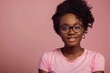 Attractive african american woman wearing pink t-shirt and glasses. Isolated on pink background.