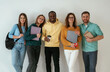 © standret - Holding notepads and coffee cup. Group of young people are standing against white background