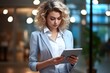 © Alexander Chaykin - A woman in a business suit using a tablet, suitable for business and technology concepts