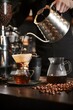 l café dorado gotea en una jarra, un ritual de precisión y paciencia de un barista, creando una obra maestra de grano a brebaje en la alquimia del amanecer.