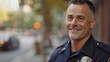 Handsome charming and smiling police officer in uniform looking at camera.