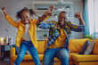 Active african funny dad little son and crazy daughter heavy metal or rock and roll lovers dancing in cozy living room relish life fooling around listening cool music scream with joy enjoy party hard