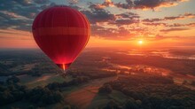 A Red Hot Air Balloon Floats Over A Valley During Sunset