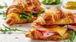 Ham and cheese croissant sandwich with dijon mustard, on a white background