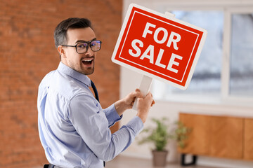 Wall Mural - Portrait of male real estate agent with FOR SALE sign in new apartment