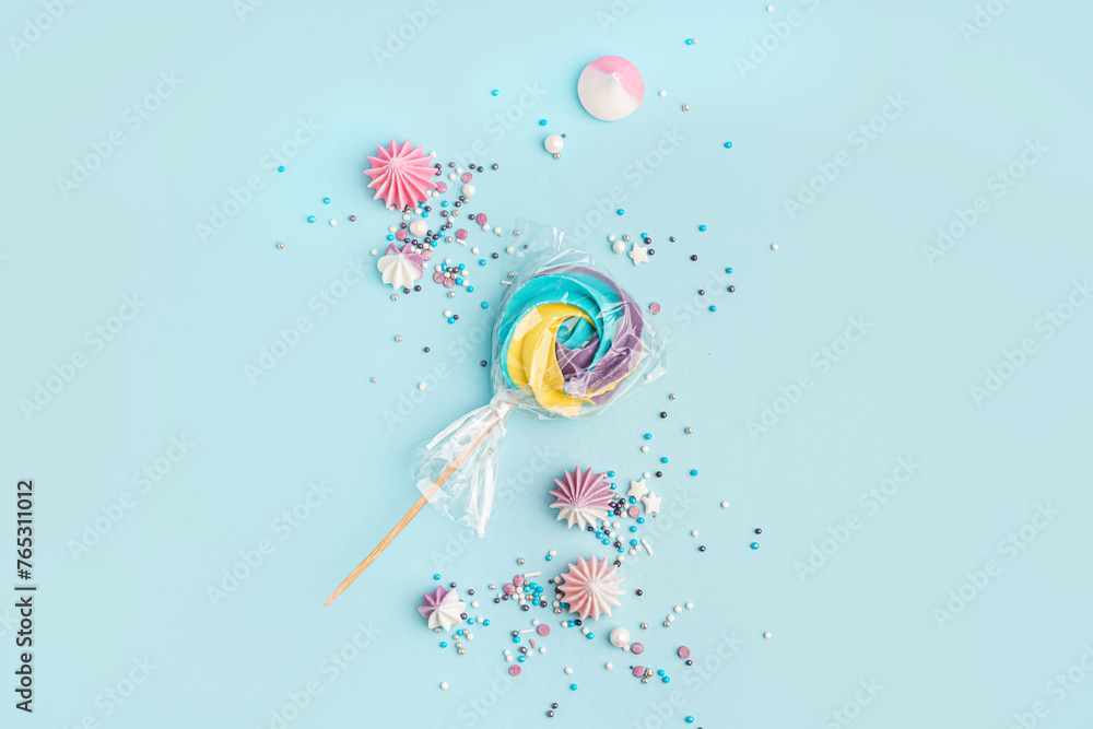 Colorful sprinkles with sweets scattered on blue background