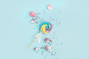 Wall Mural - Colorful sprinkles with sweets scattered on blue background