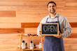 © Pixel-Shot - Male shoemaker with OPEN sign and shoes on wooden background