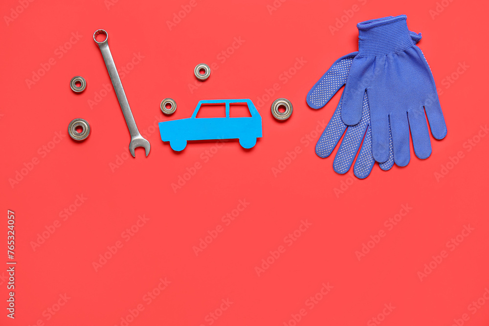 Wrench, nuts and toy car on red background. Mechanic concept