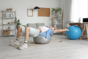 Canvas Print - Handsome man training on fitball at home