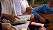 © Thew - The people read and studied the bible at the park and prayed together. sharing the gospel with a friend. Holy Bible study reading together on Sunday.Studying the Word Of God With Friends. Education.