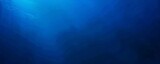 Fototapeta Do akwarium - Deep blue ocean panorama with sunlight piercing through the water over a coral reef.