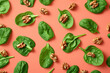 Fresh spinach leaves and crunchy walnuts arranged on a vibrant pink background, top view flat lay composition