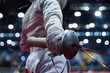 Fencer holding a foil and protective mask in his hand at a fencing tournament
